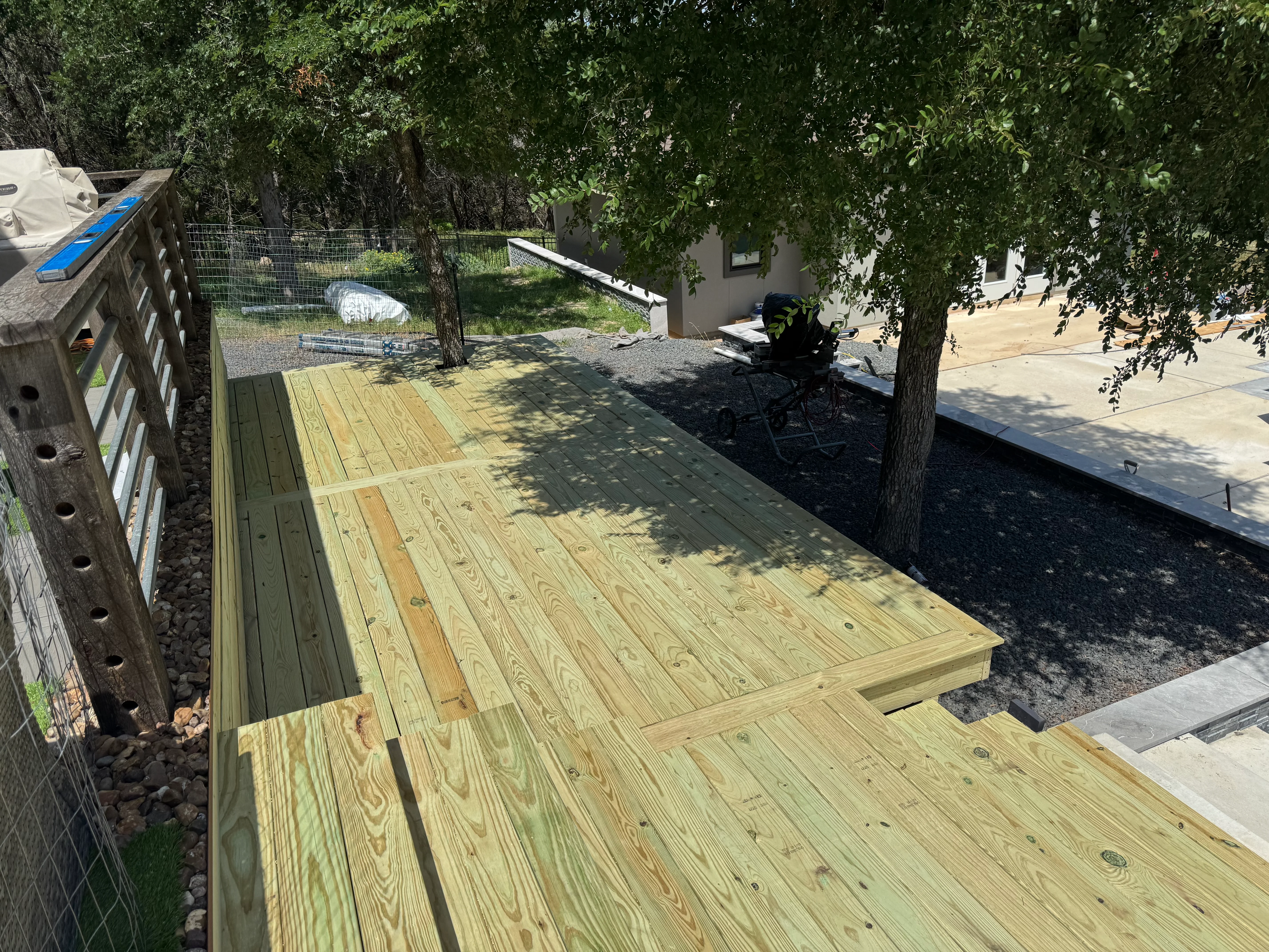 Newly installed pressure-treated wood deck with dimensional boards and framing