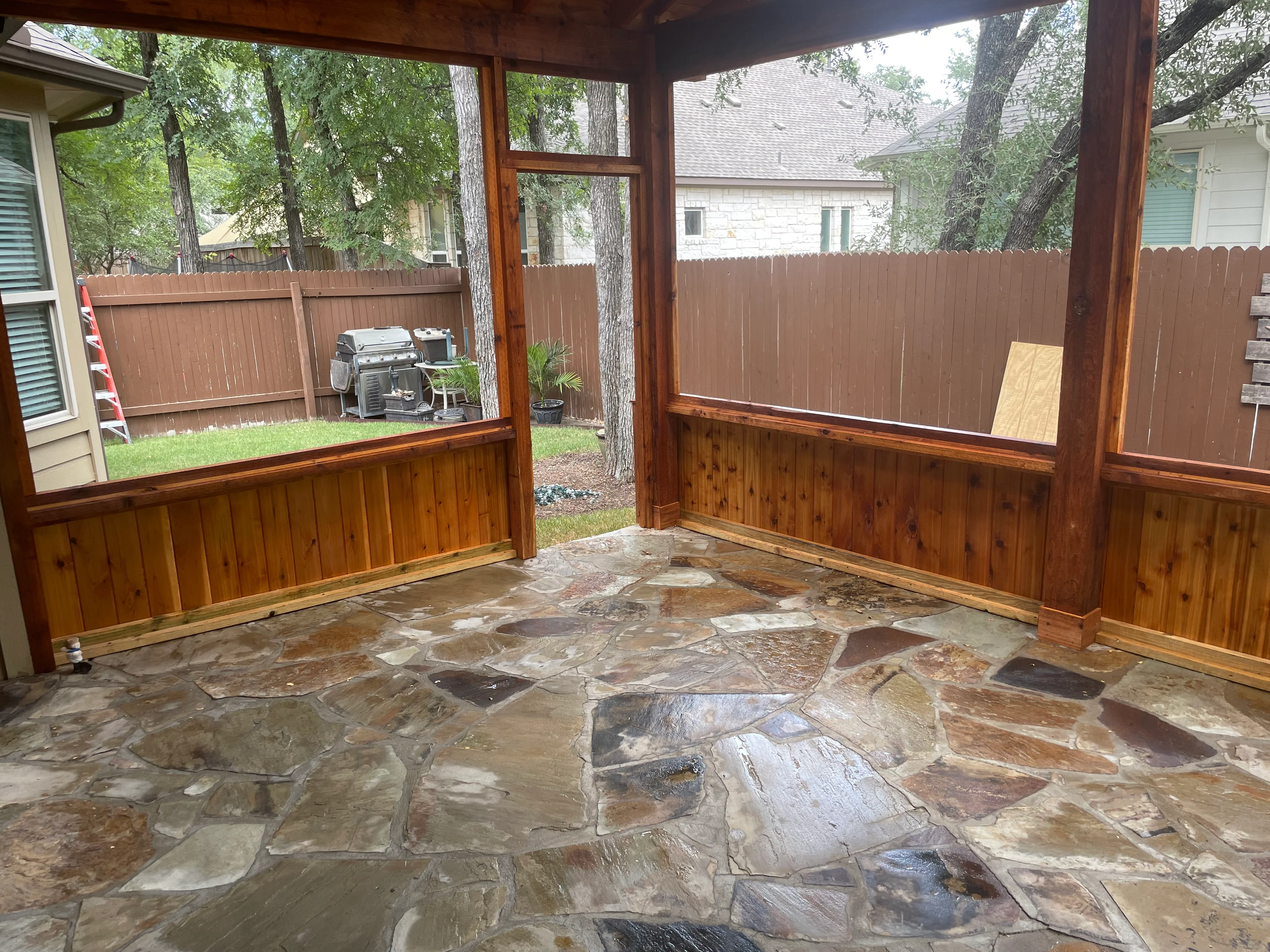 Screened patio with wood framing, windows, and flagstone flooring