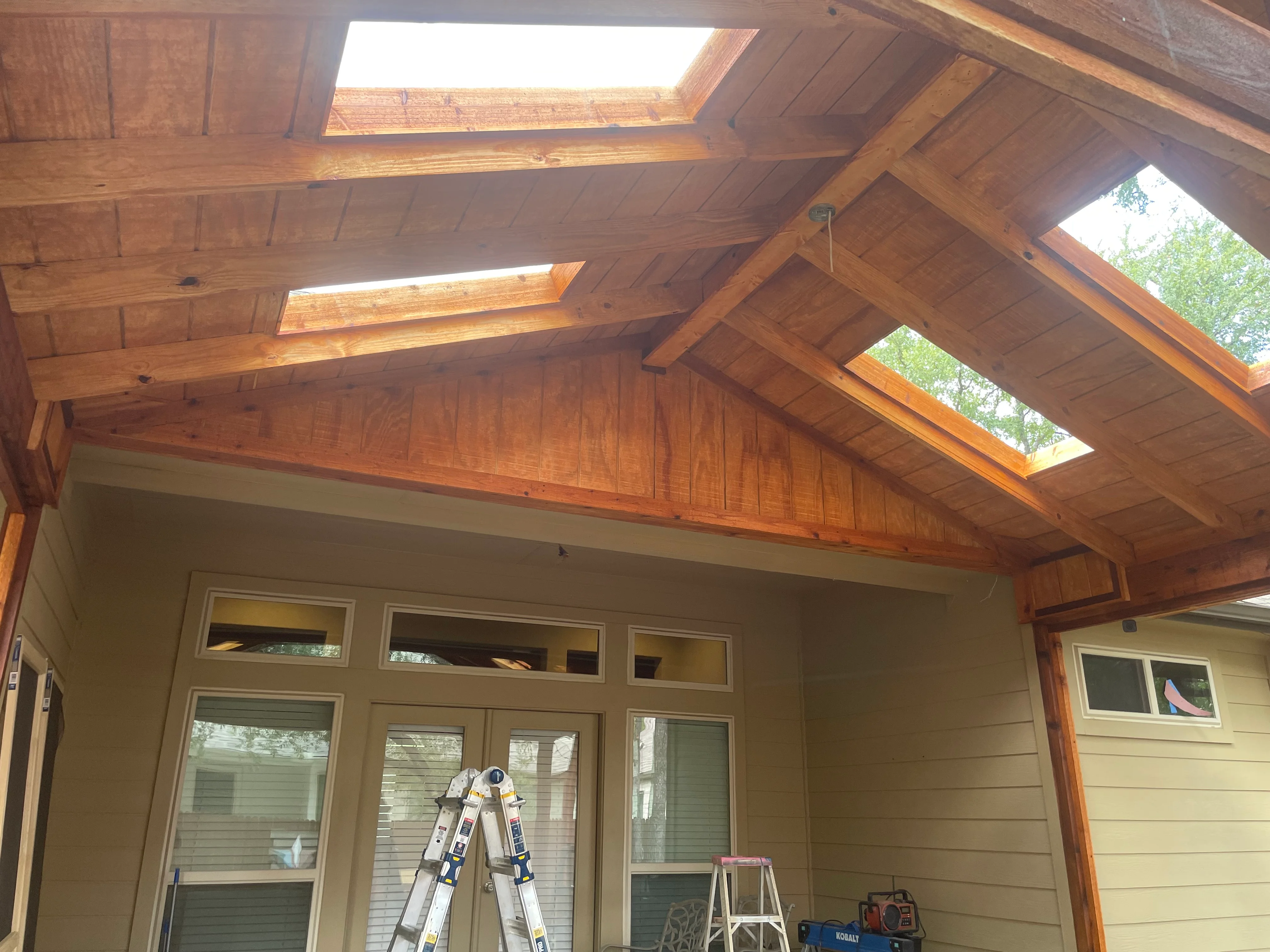 Cedar patio cover with exposed beams, skylights, and tongue-and-groove ceiling panels