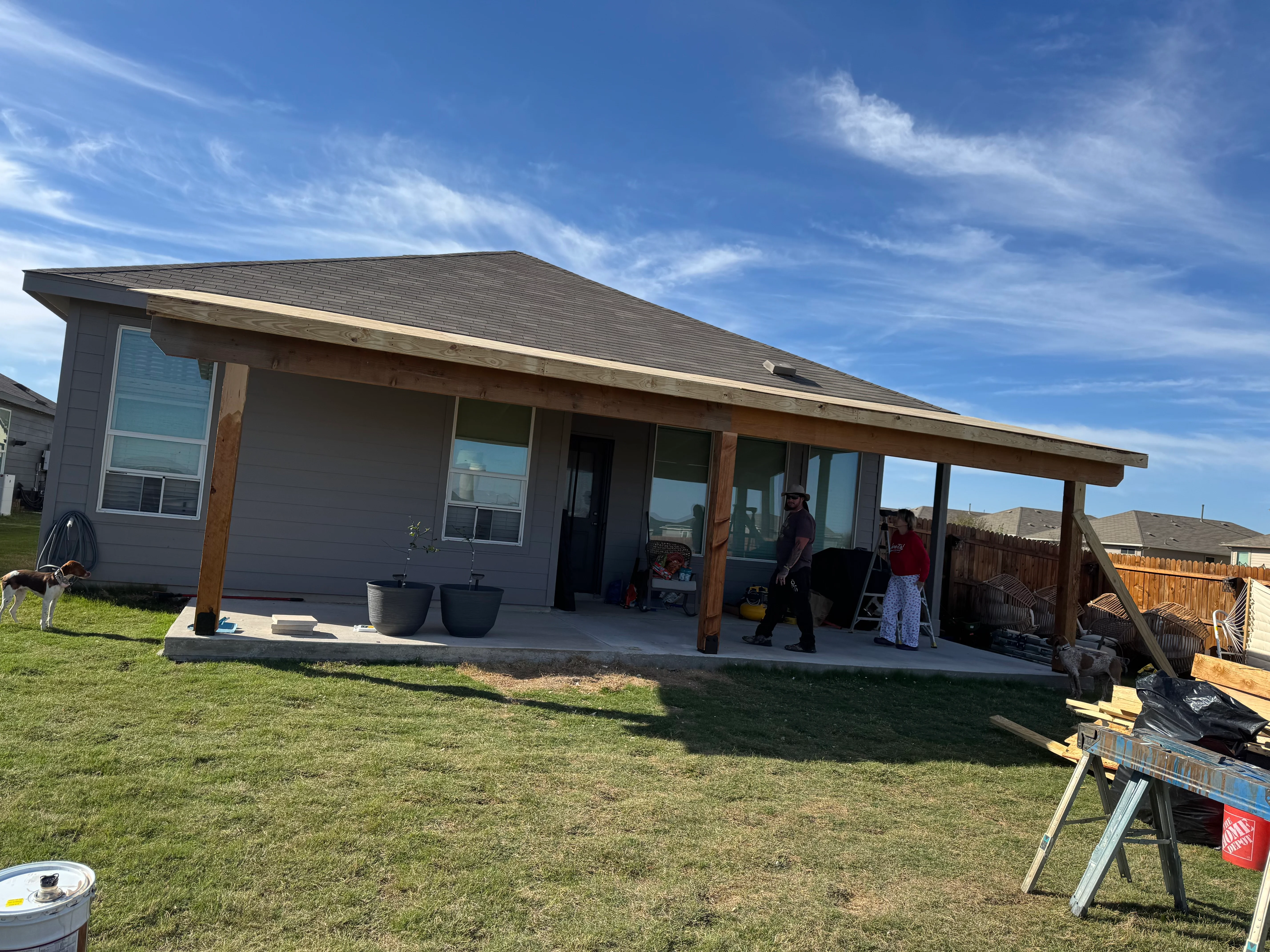 Concrete patio with wood beam pergola cover attached to modern home
