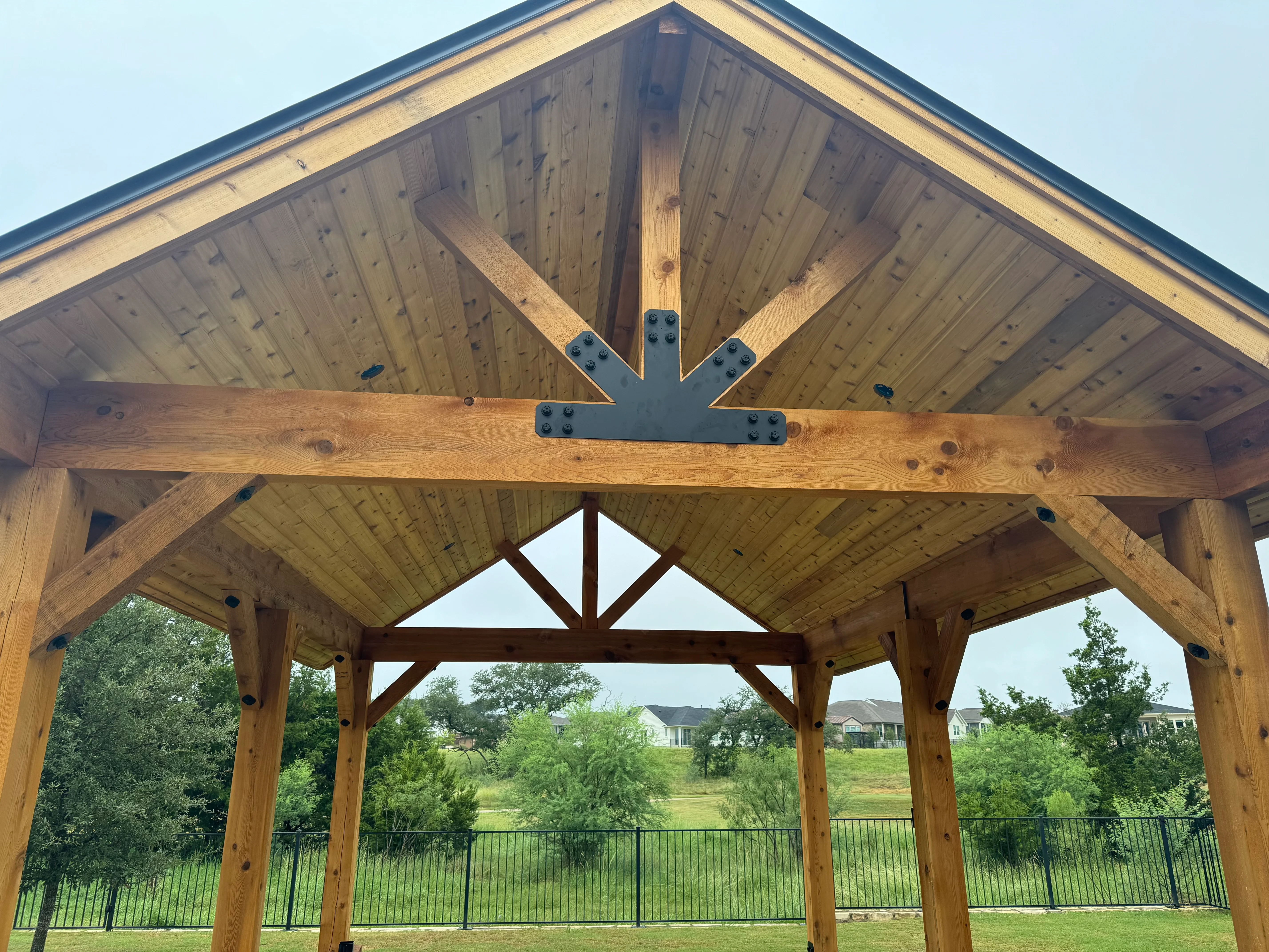 Timber frame pavilion with gable roof, exposed beams, and tongue-and-groove ceiling