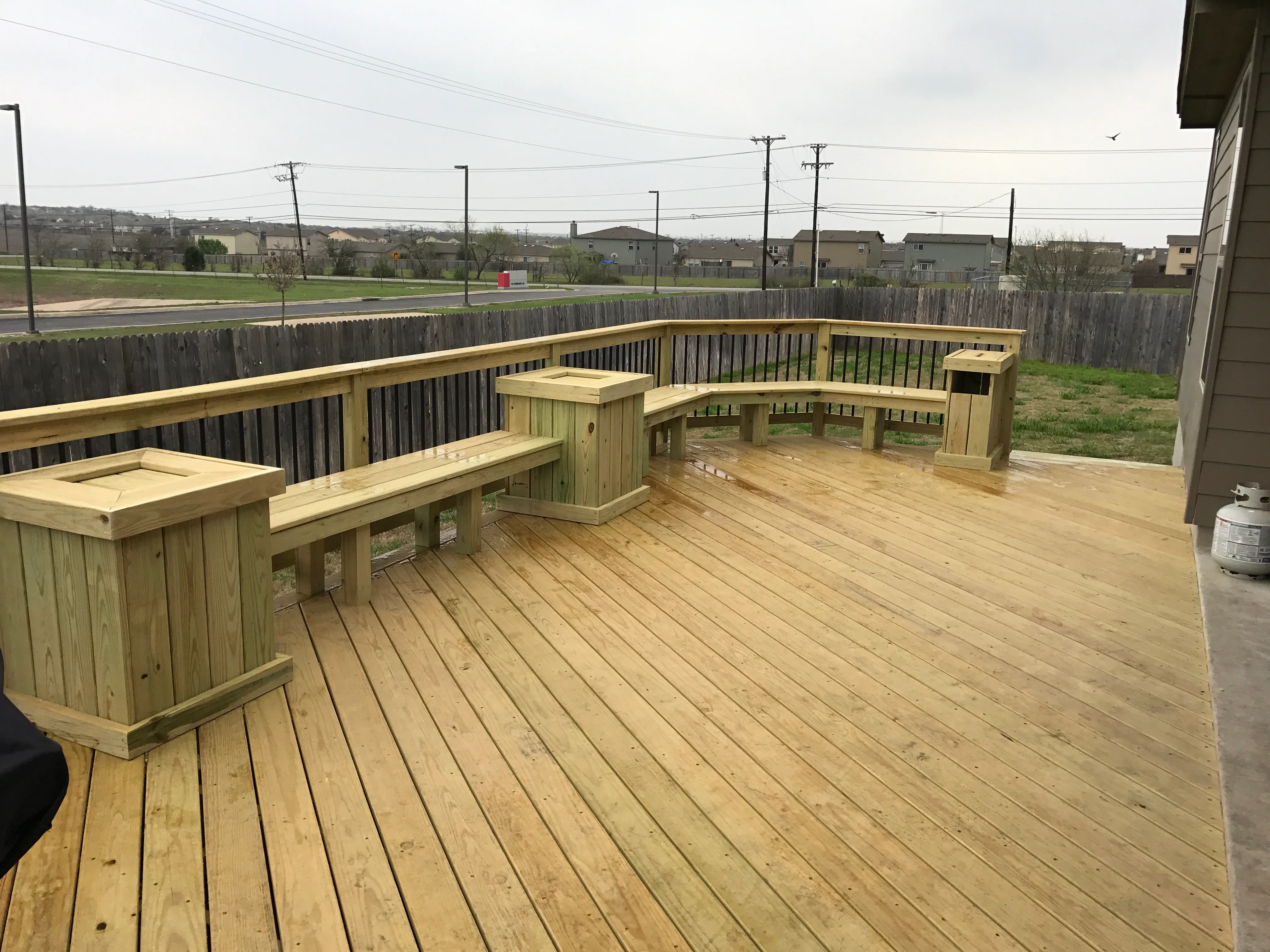 Pressure-treated wood deck with built-in benches, planters, and composite railing