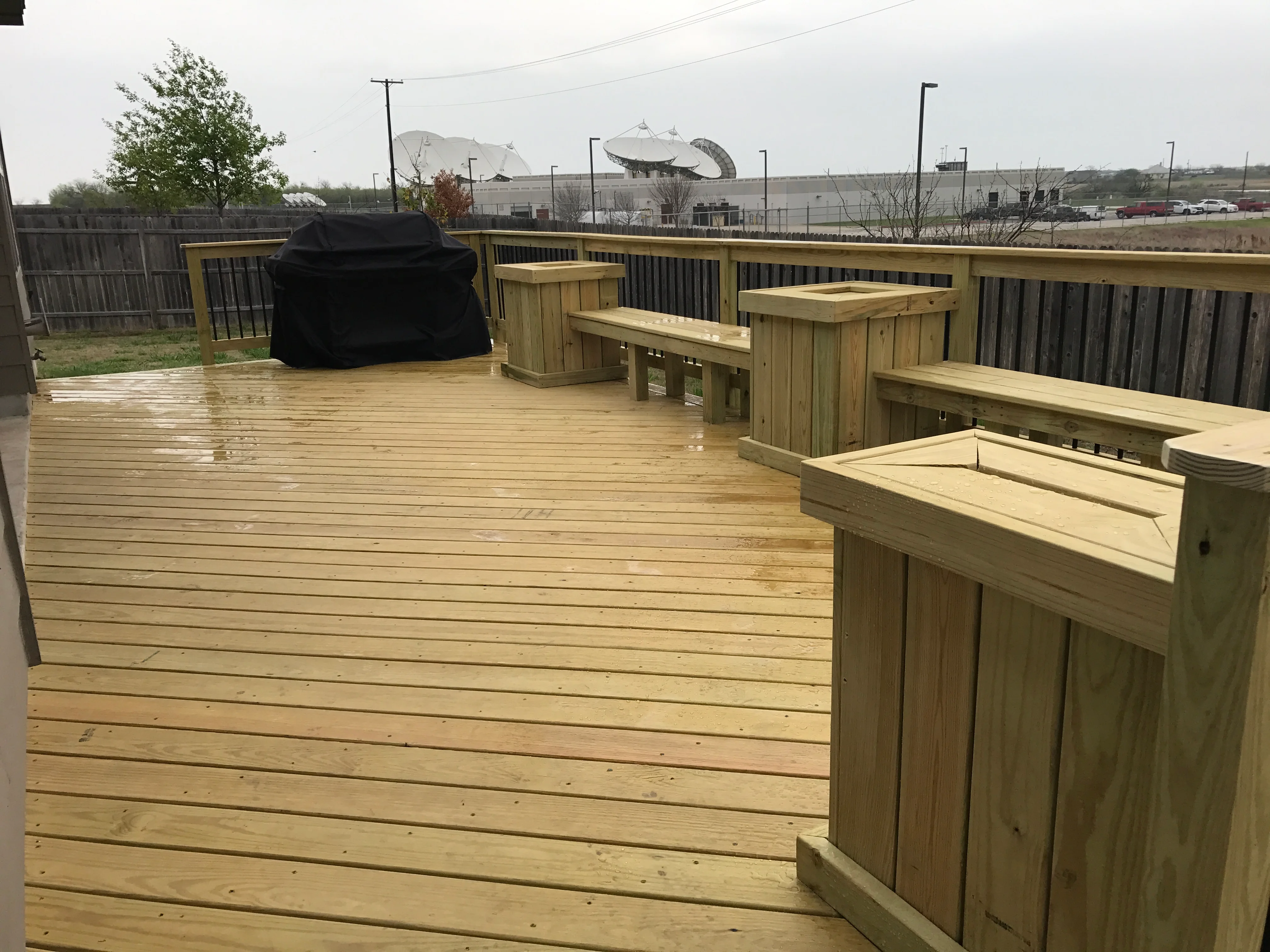 Pressure-treated wood deck with built-in planters, benches, and metal-baluster railing system